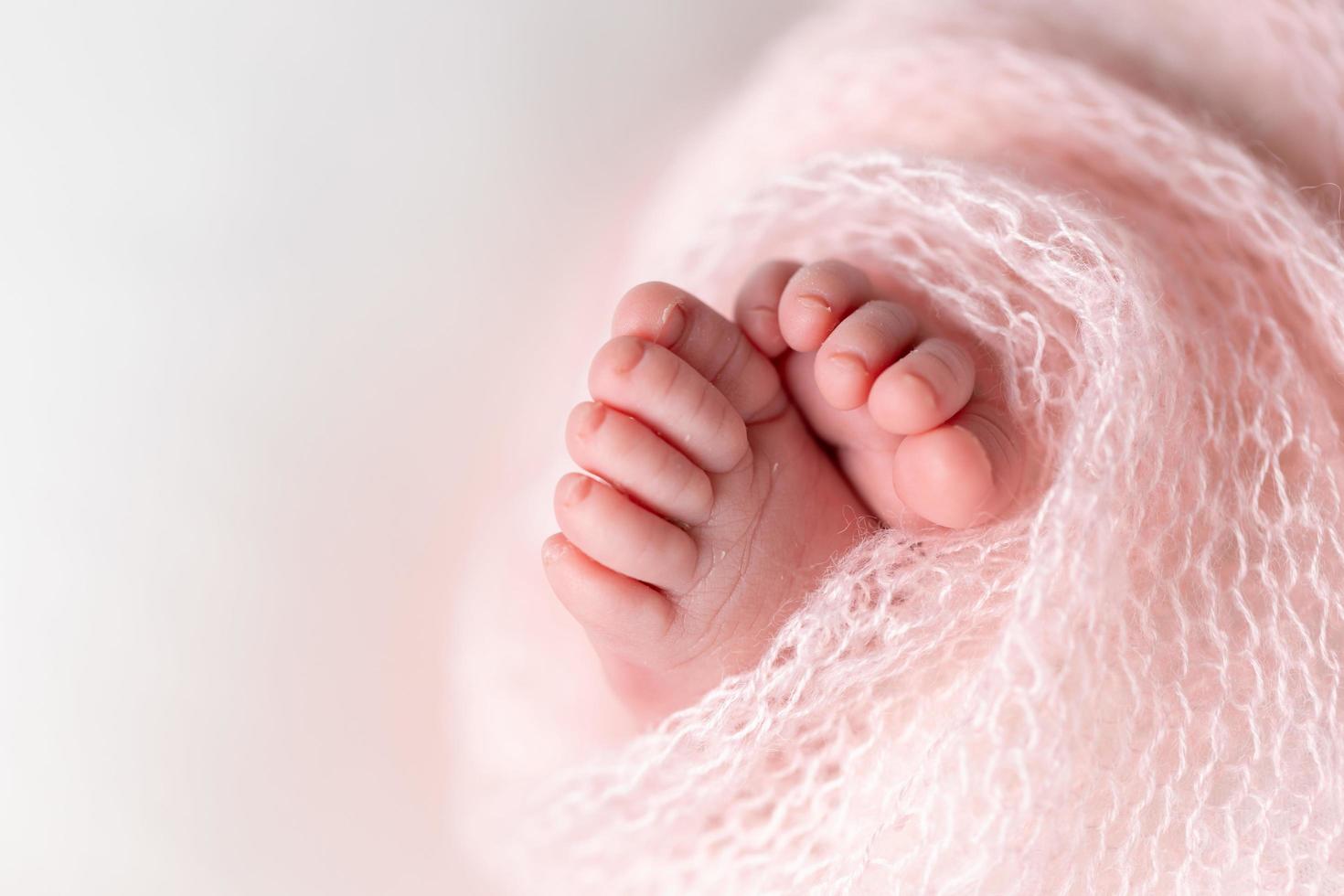 närbild av nyfödd fötter insvept i en stickat filt foto