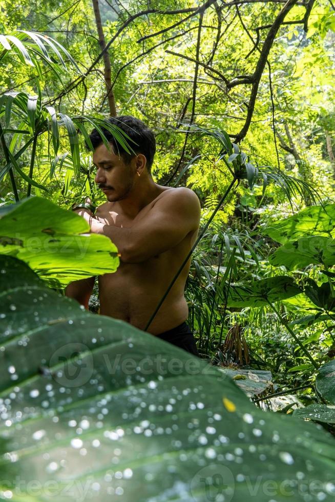 man sett upp stänga, utan skjorta håller på med sträckor på yoga matta, träning, latin Amerika foto