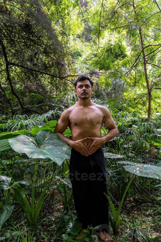 ung man håller på med meditation på en trappa i en skog, mexico foto