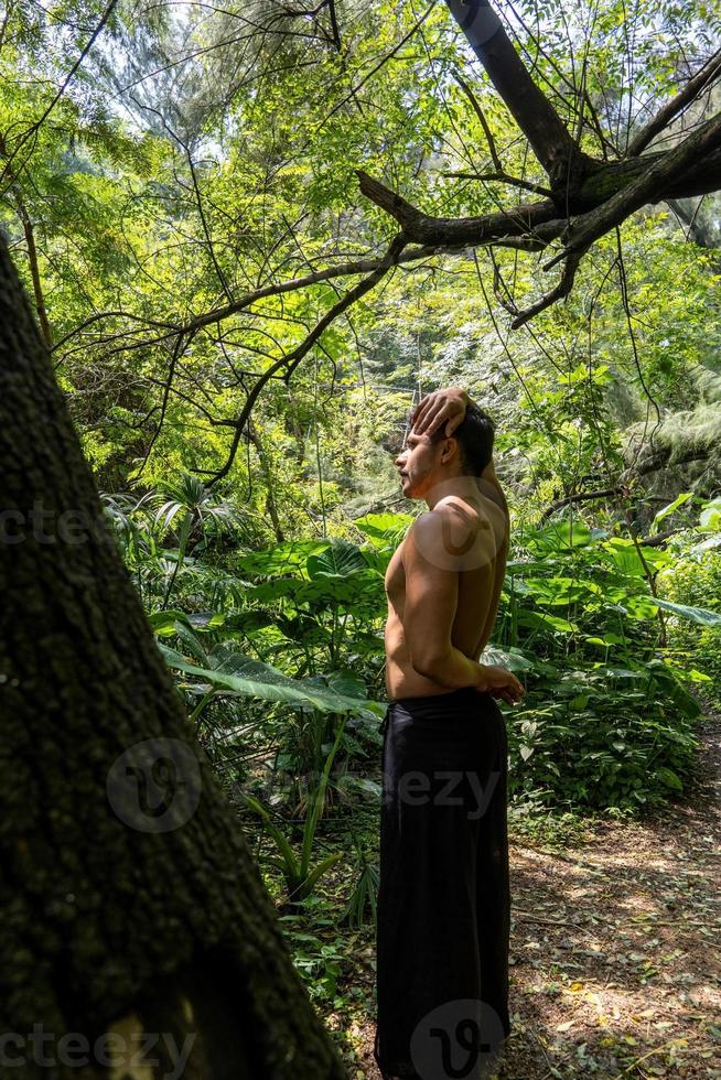 ung man, håller på med yoga eller reiki, i de skog mycket grön vegetation, i Mexiko, guadalajara, bosque colomos, latinamerikan, foto