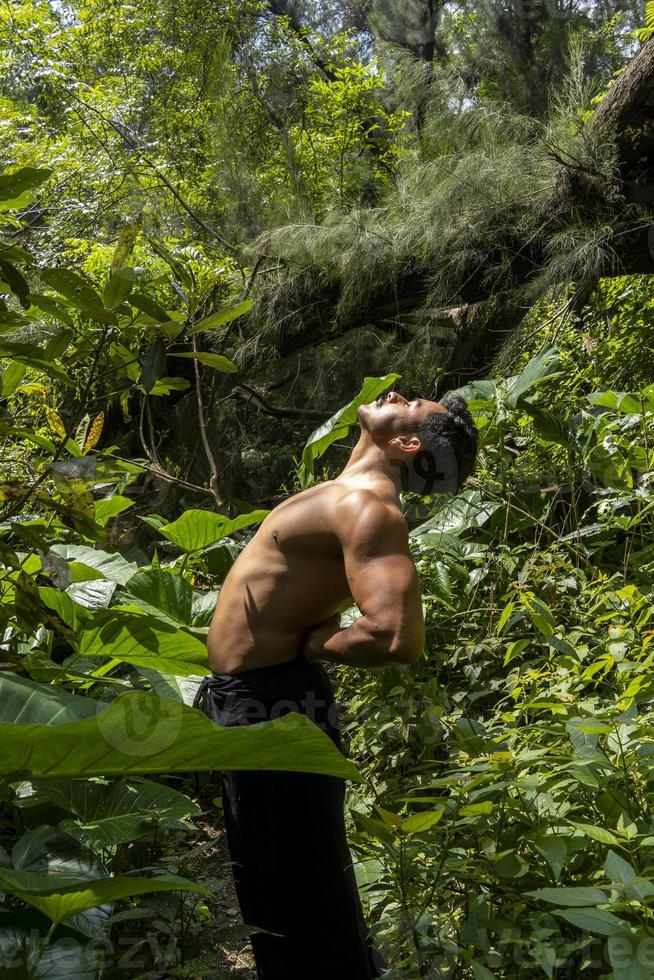 man sett upp stänga, utan skjorta håller på med sträckor på yoga matta, träning, latin Amerika foto