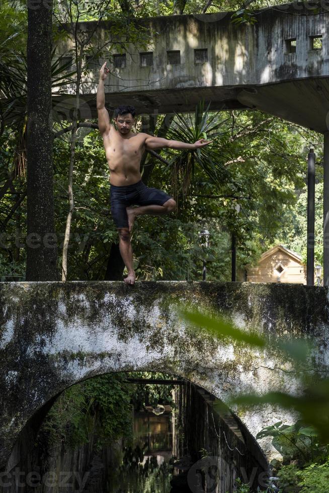 ung man, håller på med yoga eller reiki, i de skog mycket grön vegetation, i Mexiko, guadalajara, bosque colomos, latinamerikan, foto