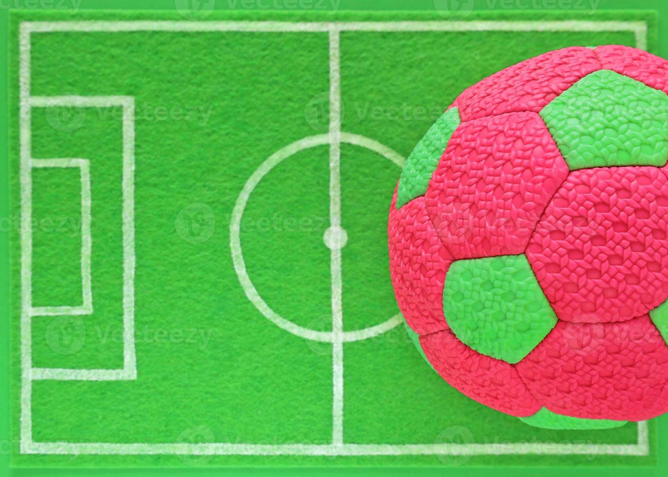 färgrik rosa och grön barn fotboll boll på mini fotboll fält tillverkad av grön känt, topp se. baner för barns team sporter sektion eller läger, inomhus- på skola, utomhus- på stadion. kopia Plats. foto
