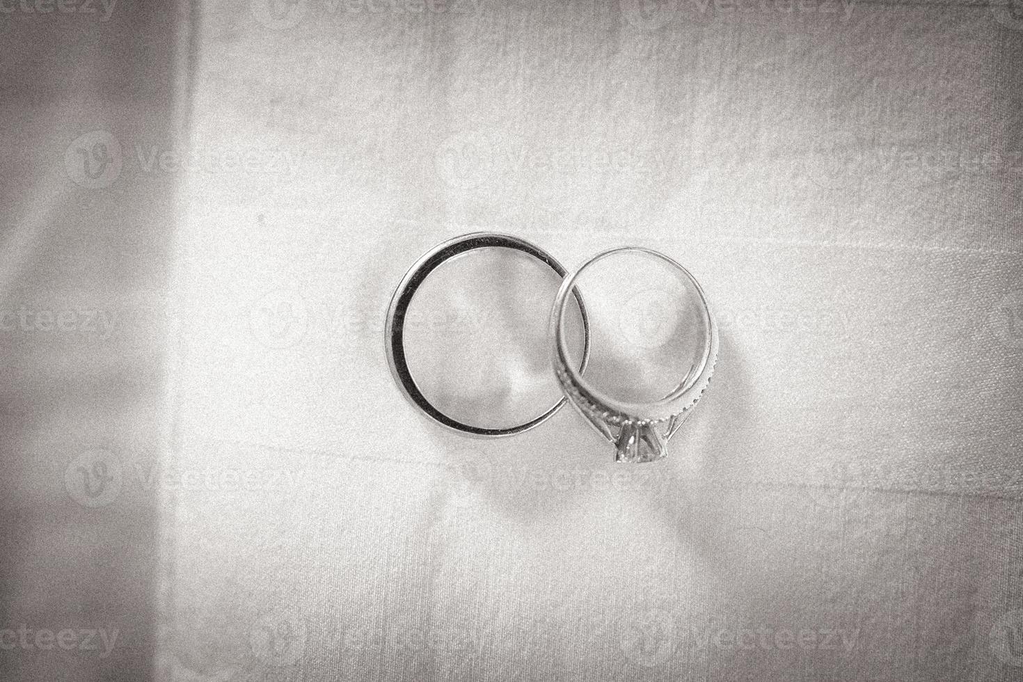 två bröllop ringar på en texturerad bakgrund foto