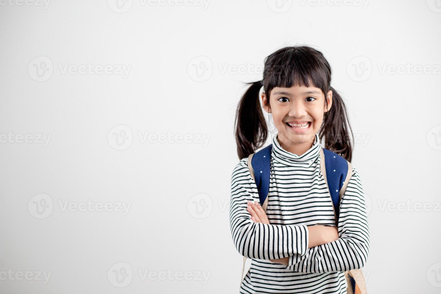 porträtt av asiatisk barn i skola enhetlig med skola väska på vit bakgrund foto