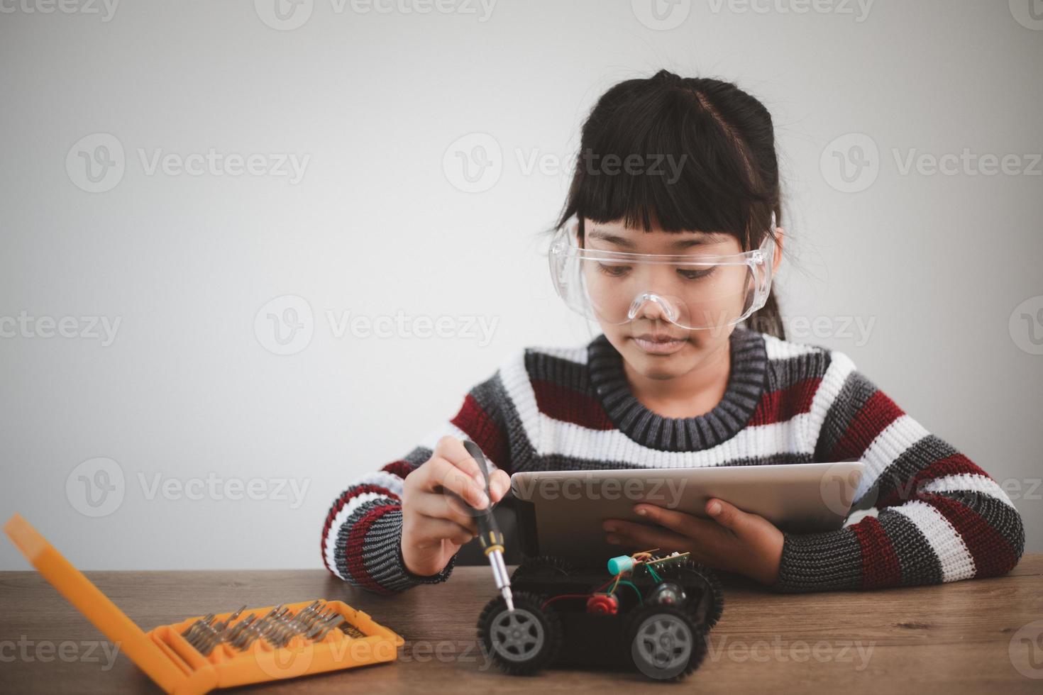 Asien-studenter lär sig hemma i kodning av robotbilar och kablar för elektronikkort i stam, steam, matematik ingenjör vetenskapsteknik datorkod i robotik för barn-koncept. foto