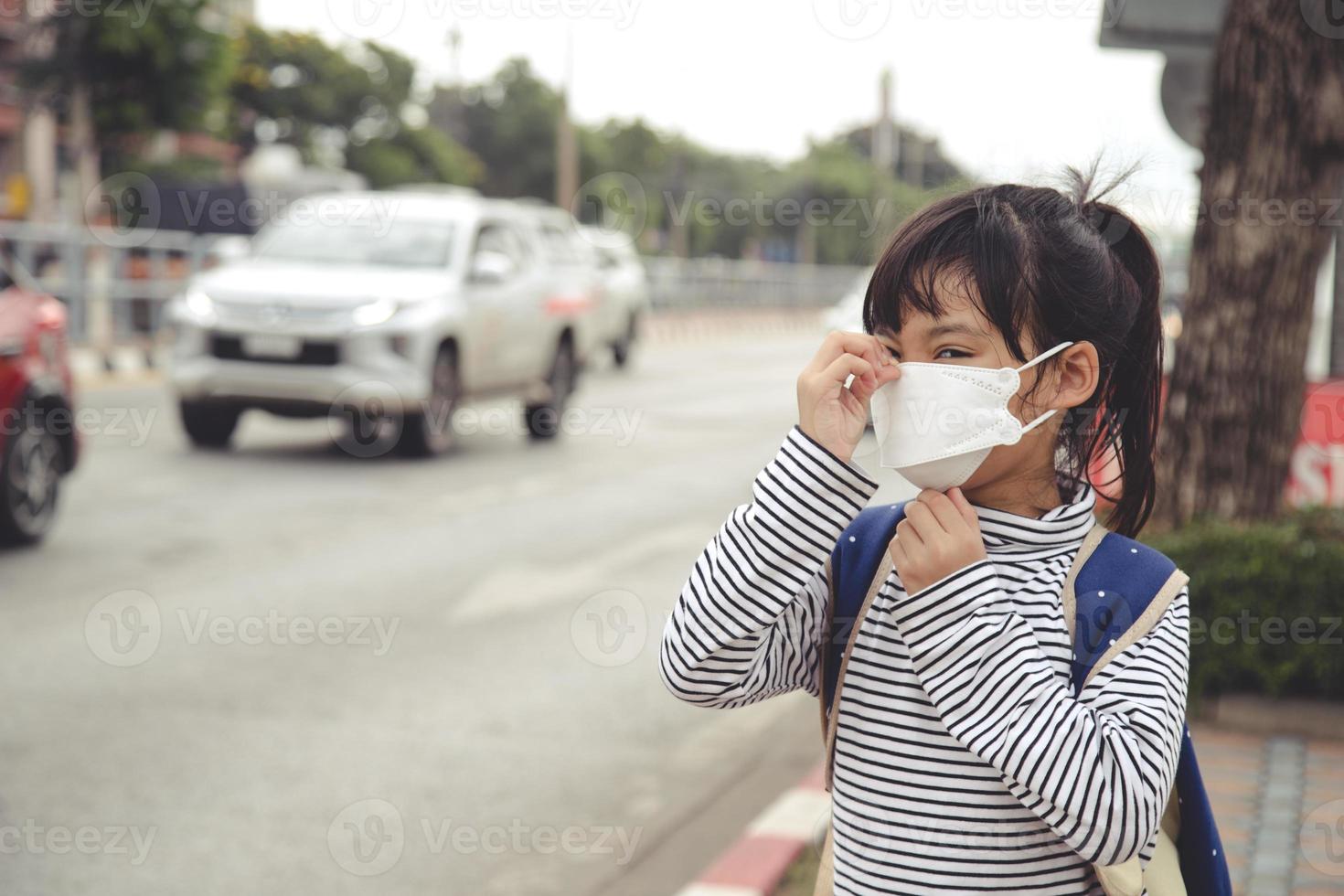 söt asiatisk barn flicka bär skydd mask till mot luft smog förorening med pm 2.5 i de stad foto