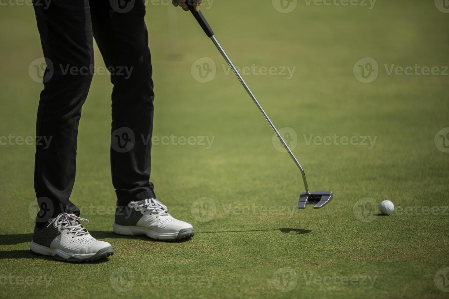 golfspelare på den sätta gröna slå bollen i ett hål foto