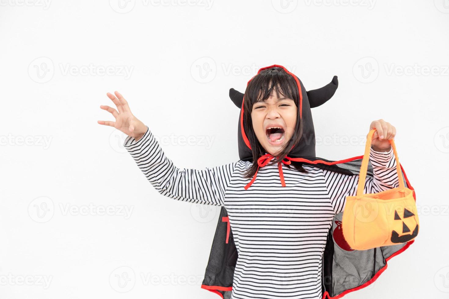 rolig halloween unge begrepp, liten söt flicka med kostym halloween spöke skrämmande han innehav orange pumpa spöke på hand, på vit bakgrund foto