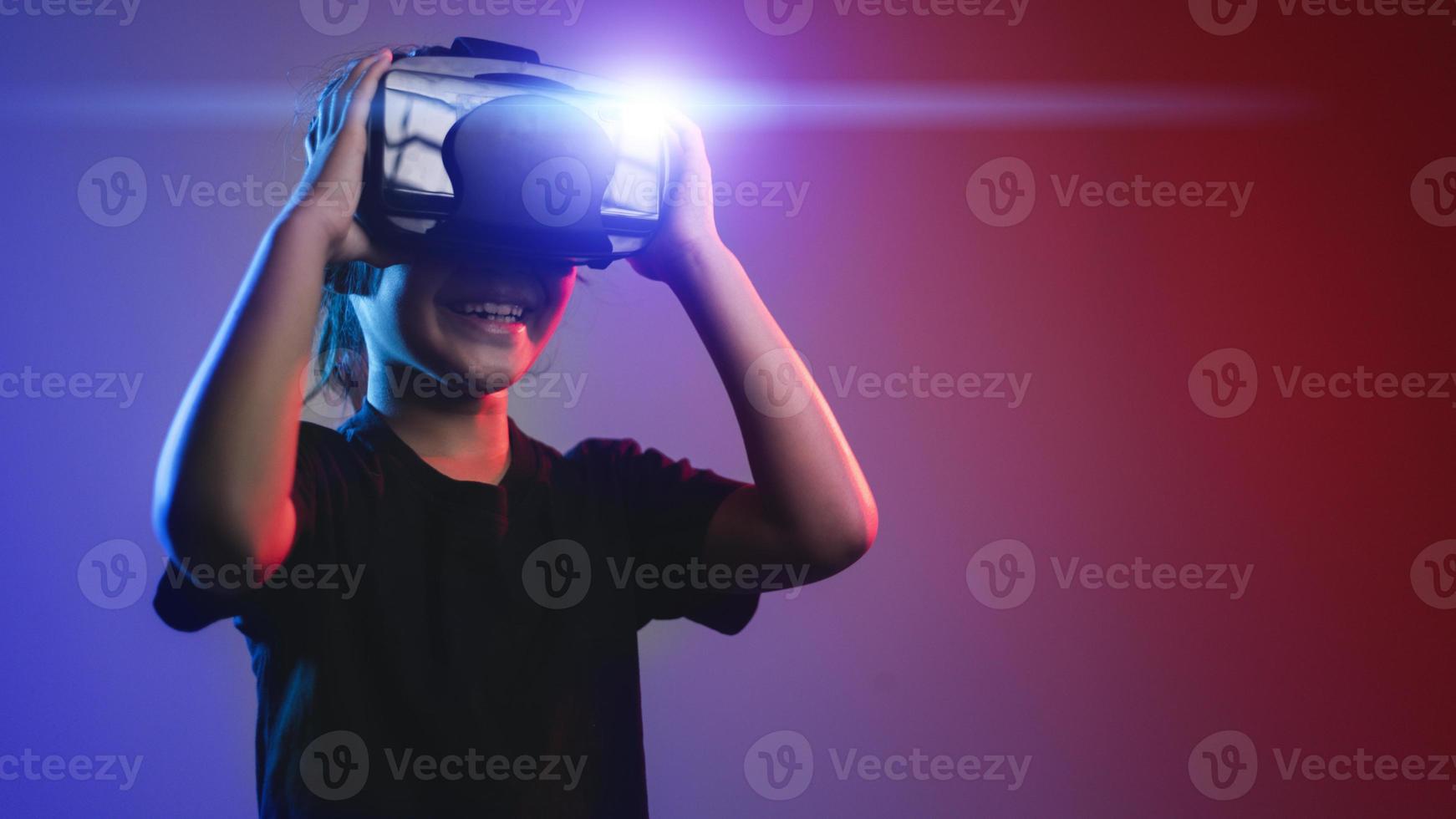 Lycklig flicka i glasögon av virtuell verklighet. förändrad verklighet, vetenskap, framtida teknologi begrepp. vr. trogen 3d glasögon med virtuell utsprång. neon ljus. foto