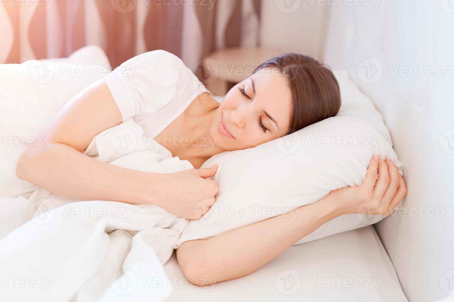 lugn lugna kvinna sovande i bekväm säng liggande på mjuk kudde ortopedisk foto