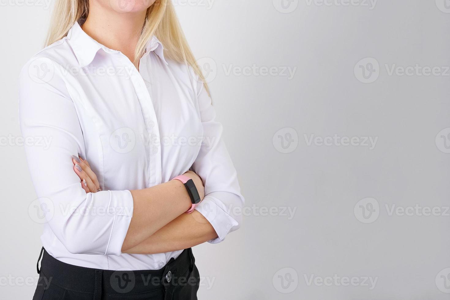 framgångsrik kvinna med vikta händer i vit skjorta på ljus bakgrund foto