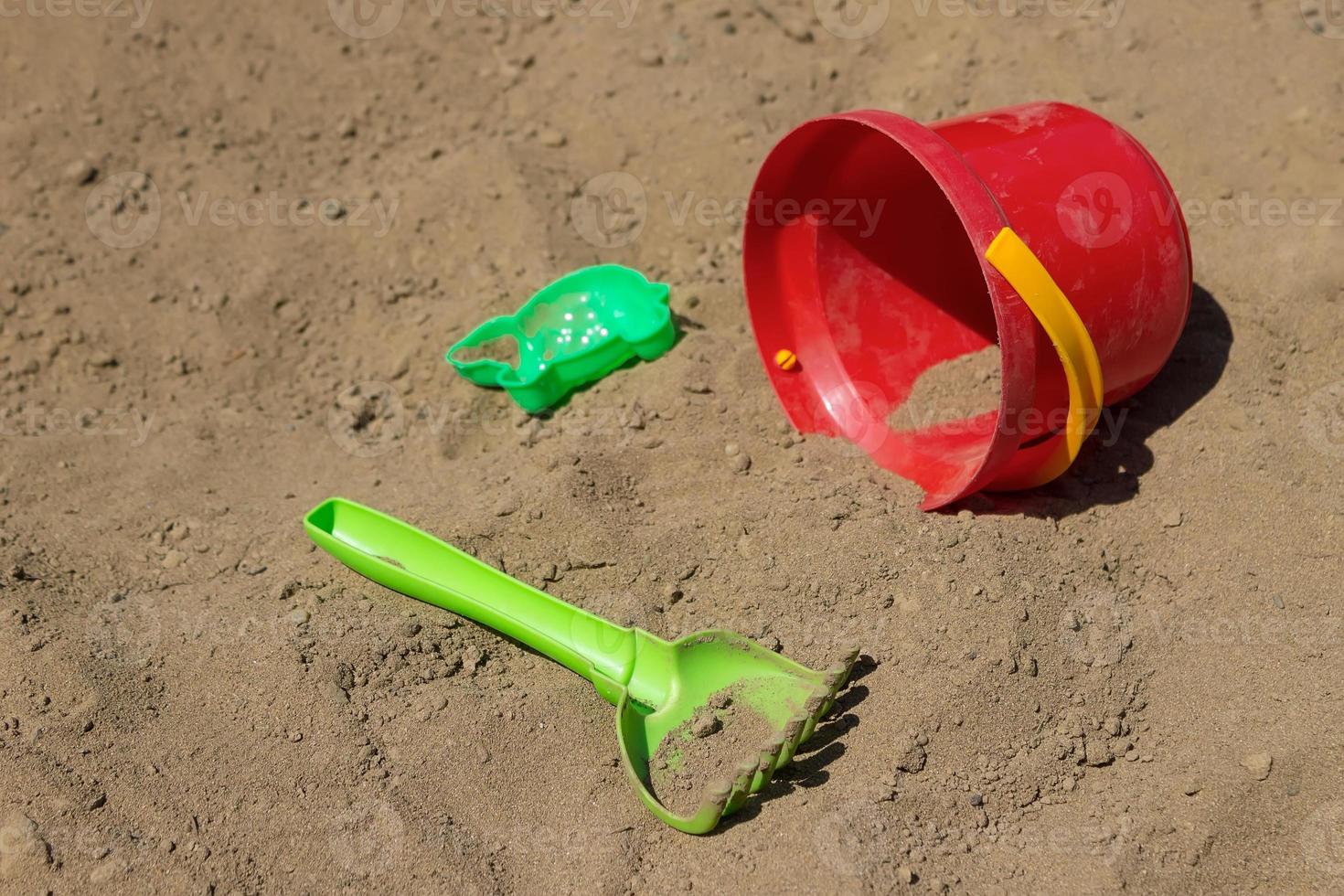 barns leksaker vänster på de strand, en hink, en skrapa och en forma för skulptera sand siffror foto