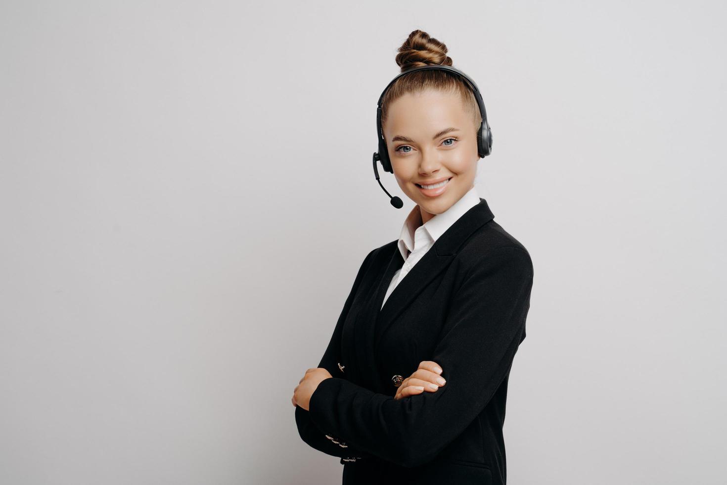 vänlig affärskvinna i headset i mörk kostym redo för webbkonferens foto