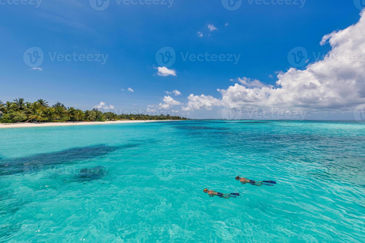 kaukasiska par turister snorklar i kristallklart turkost vatten nära ön Maldiverna. perfekta väderförhållanden på lyxresorts strandscen, lugnt havsvatten, par exotiskt vatten, undervattensvilda djur foto