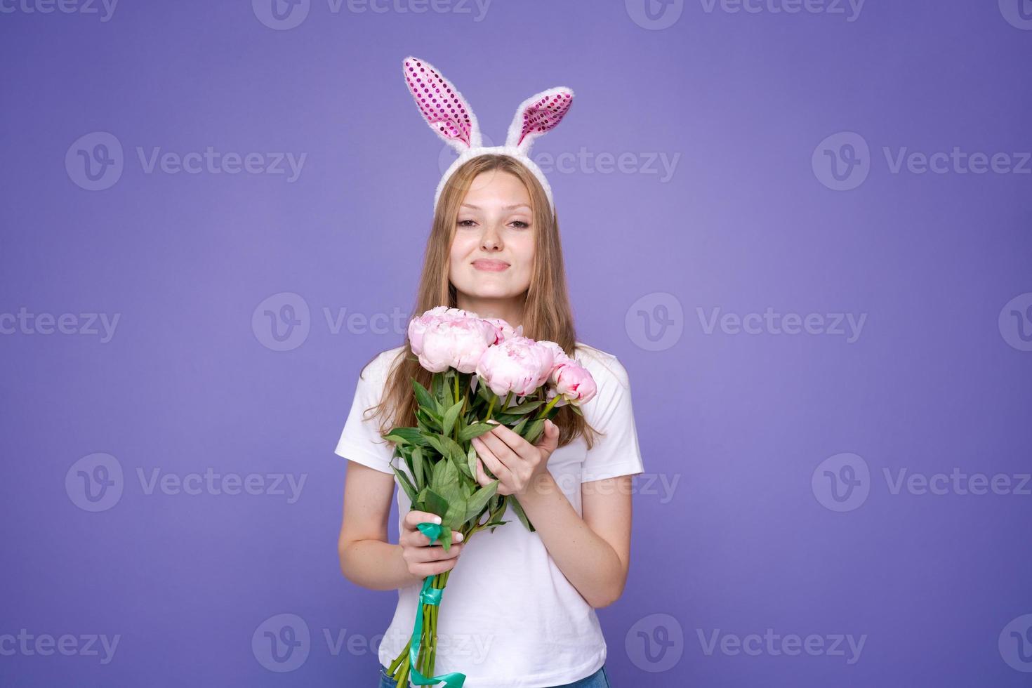 charmig Lycklig söt flicka med rosa påsk kanin öron och bukett vår foto