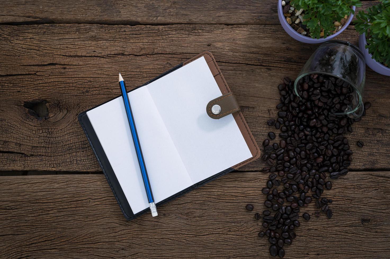 anteckningsbok med penna och kaffebönor foto