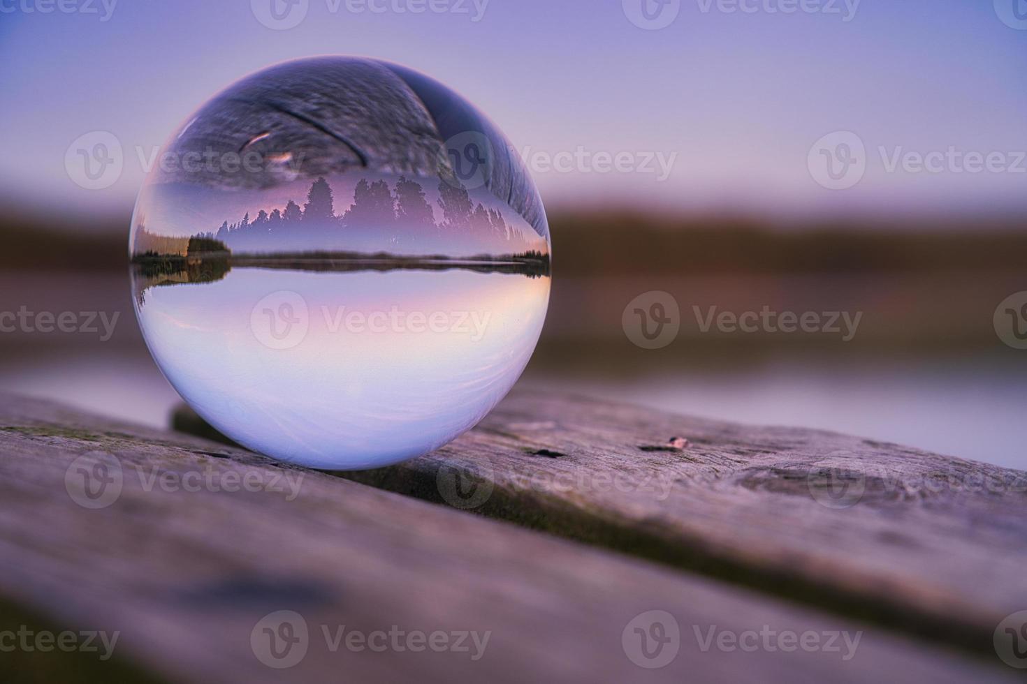 glas boll på en trä- pir på en svenska sjö på kväll timme. natur skandinavien foto