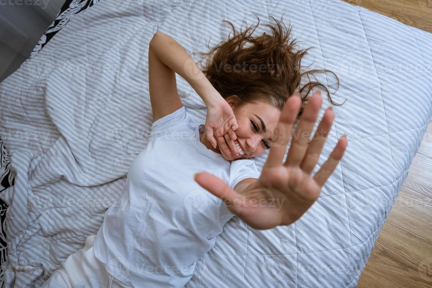 lycklig kvinna i pyjamas stretching ut henne vapen foto