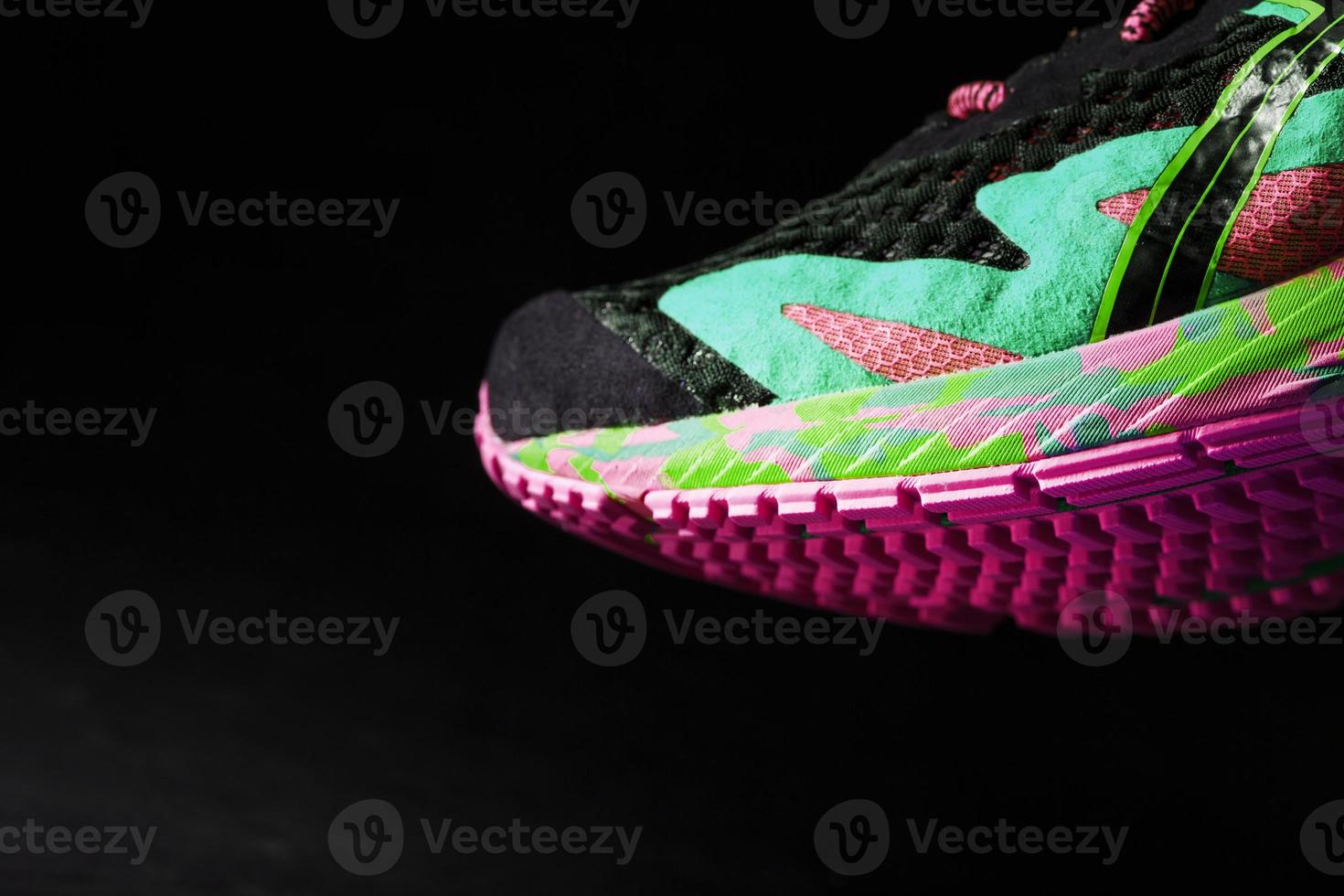 texturerad rosa enda av sporter löpning skor på en svart bakgrund. foto