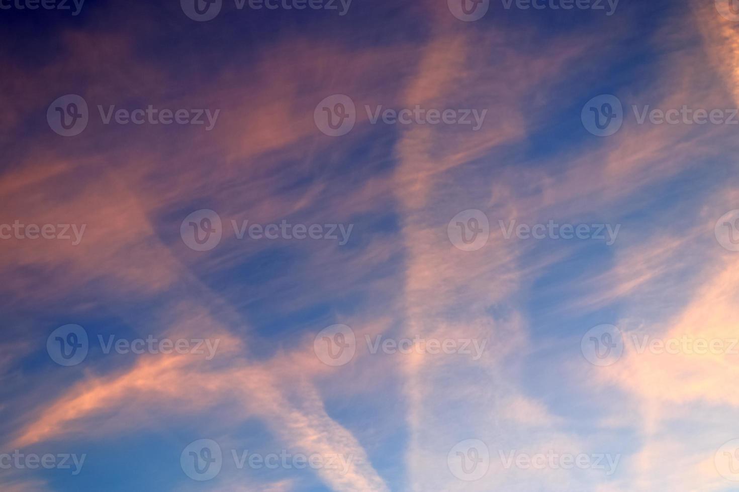 flygplanskondensation drar ihop sig på den blå himlen mellan några moln foto