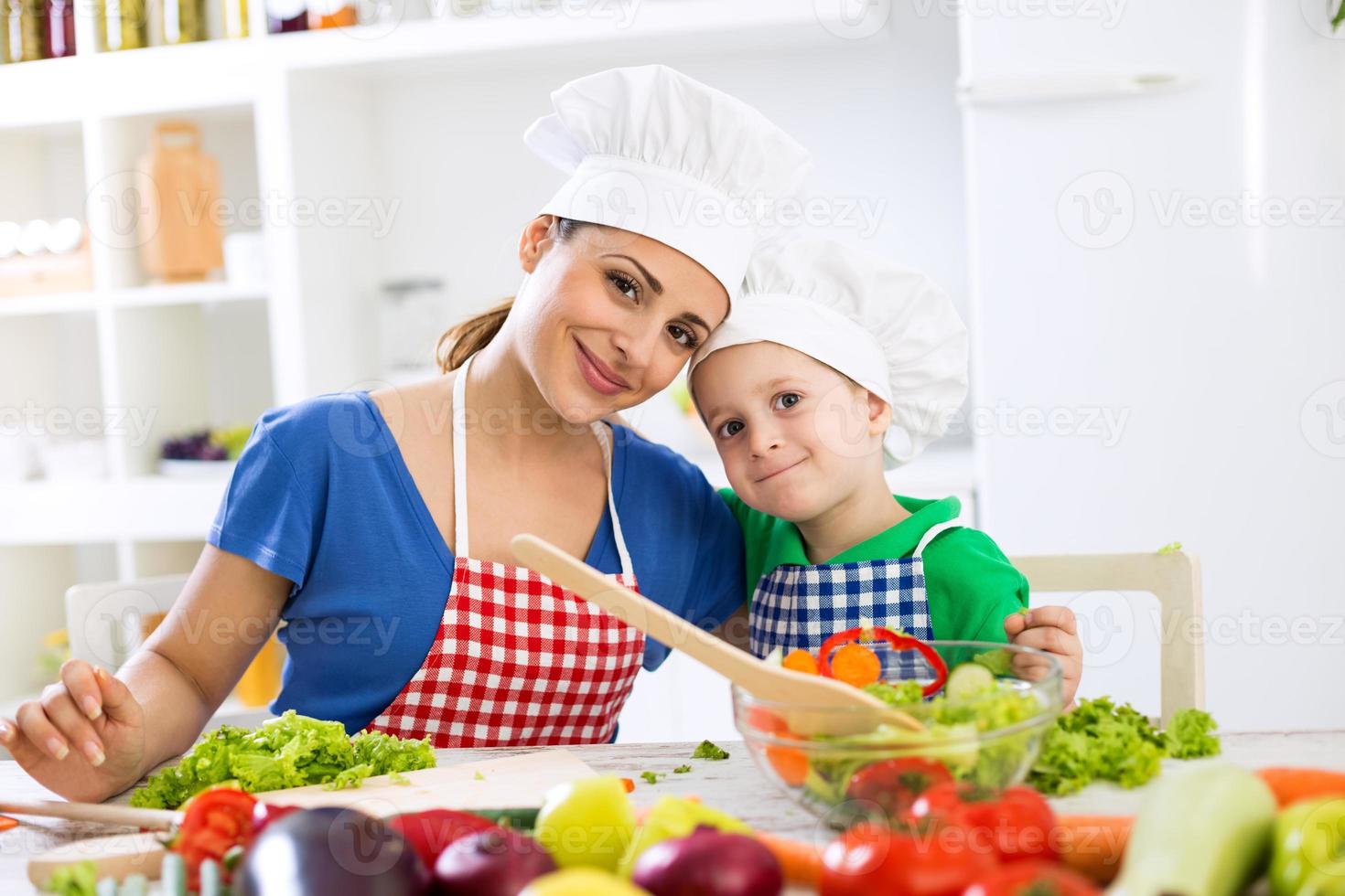 härlig mamma och unge två kockar i köket foto
