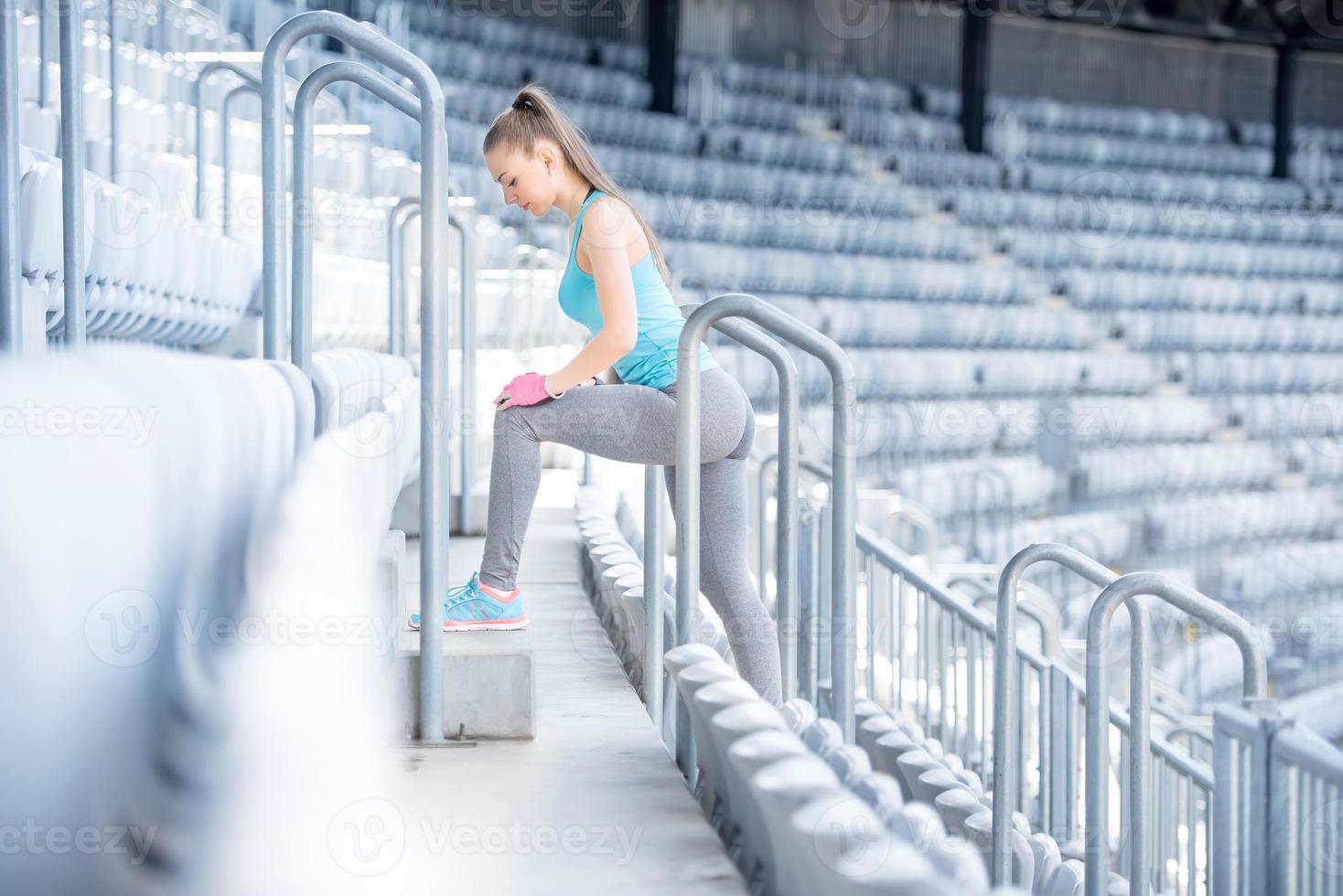 kvinnlig fitness tränare förbereder sig för träning, stretching och gör squats foto