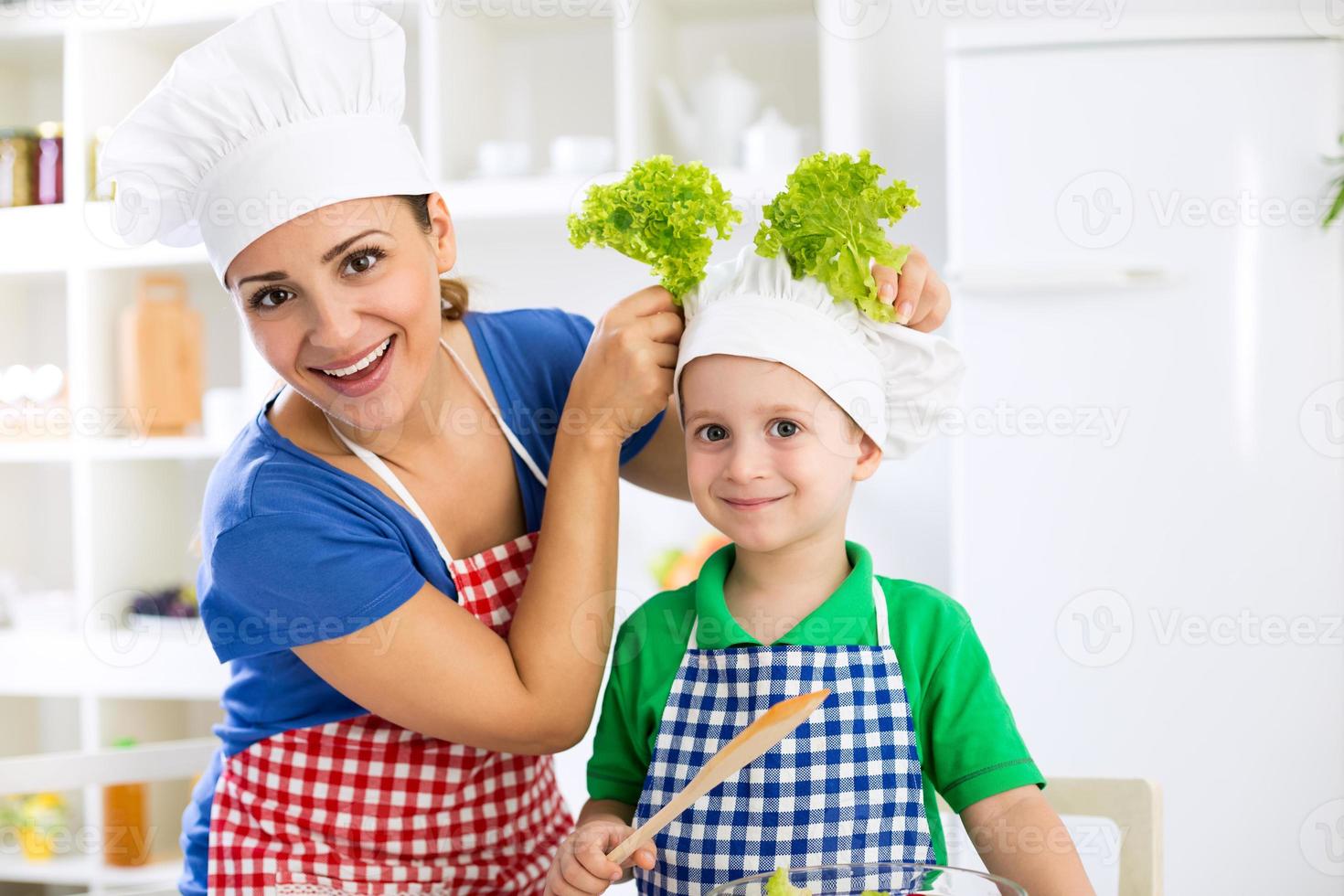 le vacker mor och barn med kockhatt förbereda lettu foto