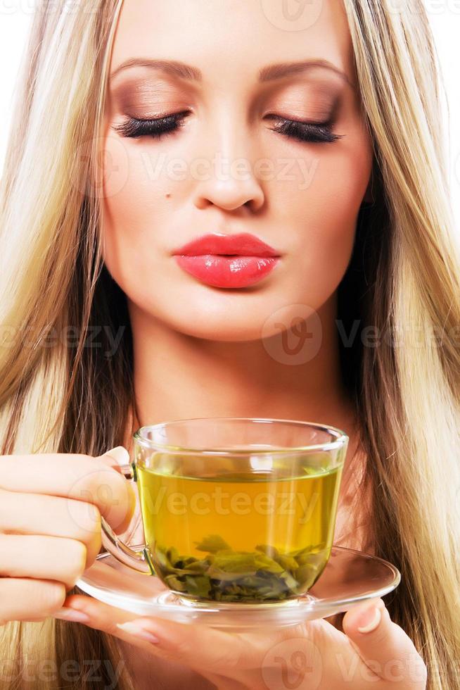 vacker kvinna med en kopp grönt te foto