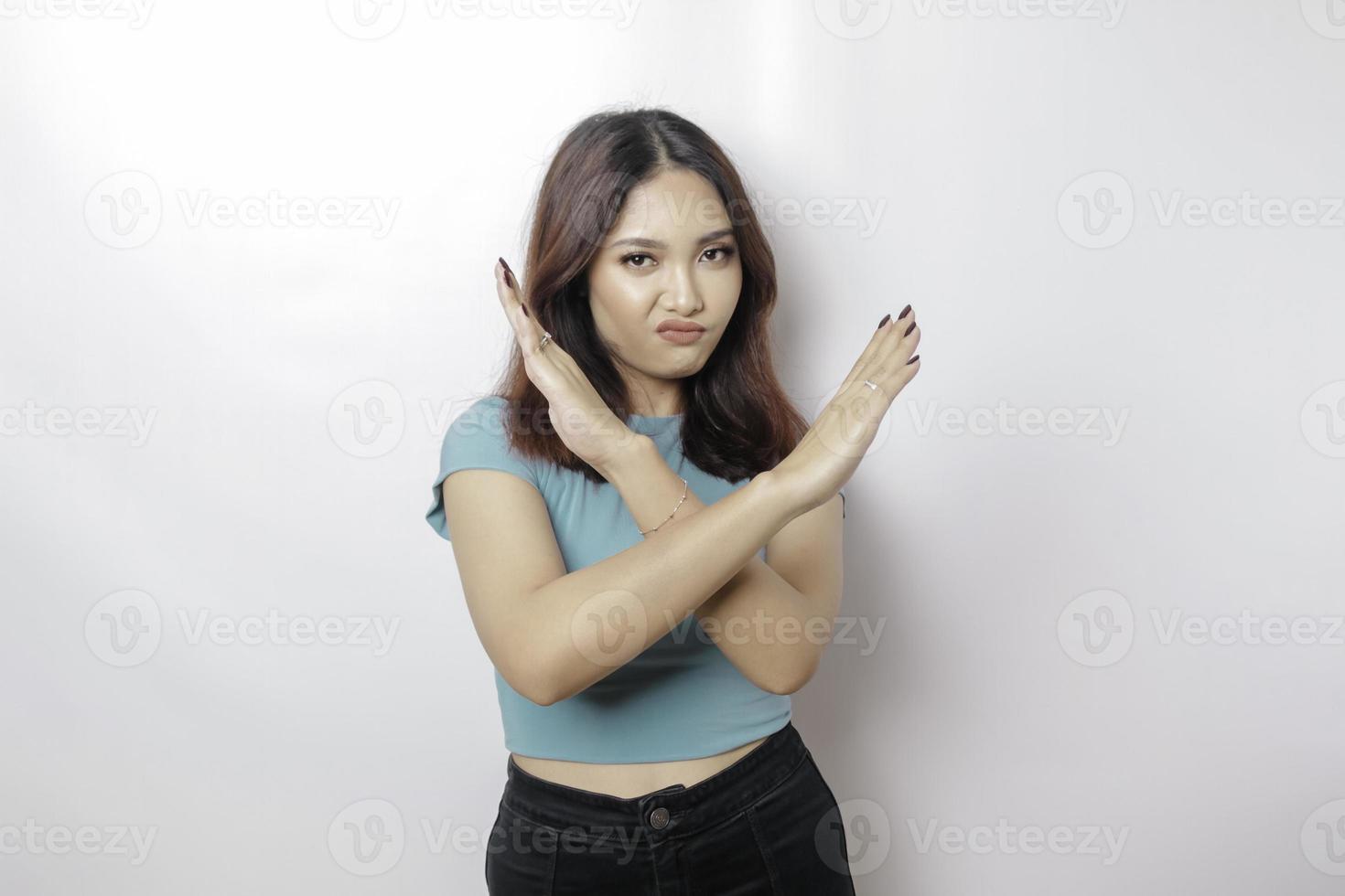 skön asiatisk kvinna bär blå skjorta med hand gest utgör avslag eller förbud med kopia Plats foto