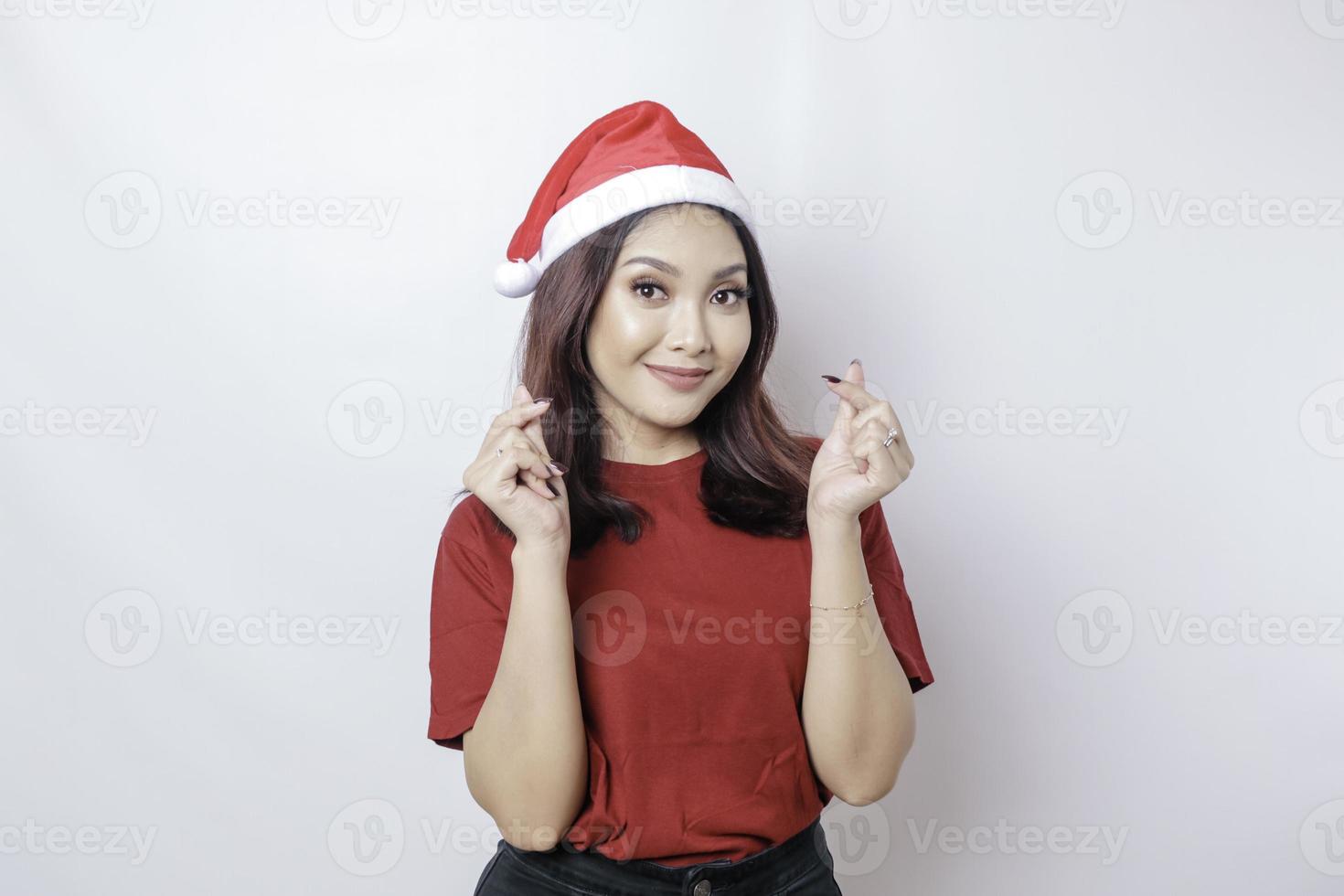 Lycklig asiatisk santa kvinna är leende och ge romantisk former hjärta gest uttrycker anbud känslor isolerat förbi vit bakgrund. jul begrepp. foto