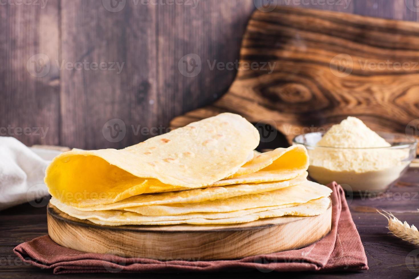 en stack av bakad mexikansk tortillas på en styrelse på de tabell. hemlagad bakverk foto