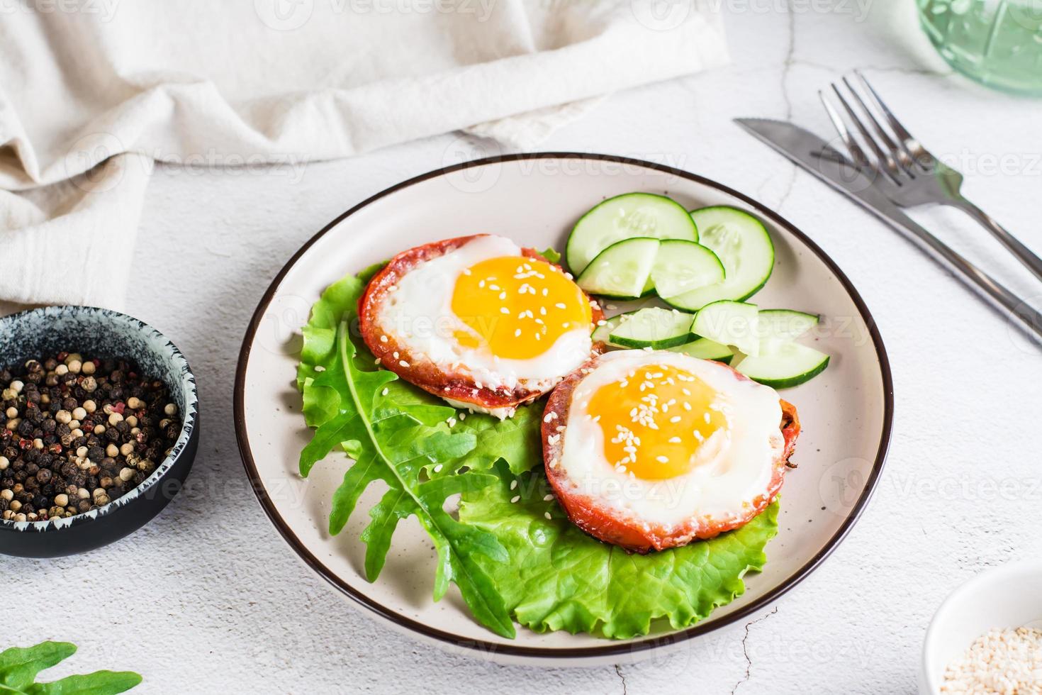 ägg bakad i tomat, arugula löv och gurka på en tallrik på de tabell. hemlagad lunch foto