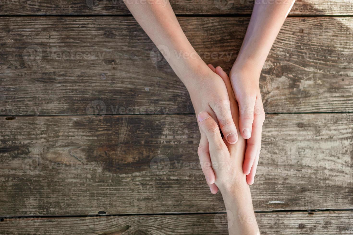 hand i hand på trä- bakgrund, ömsesidig hjälpa begrepp foto