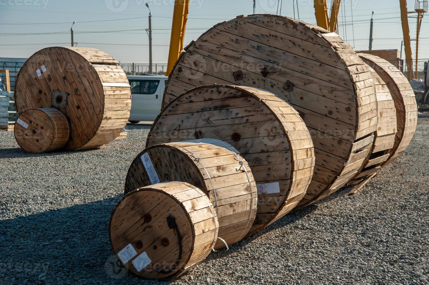 en närbild av stor industriell trä- bobiner med kabel- på en konstruktion webbplats foto