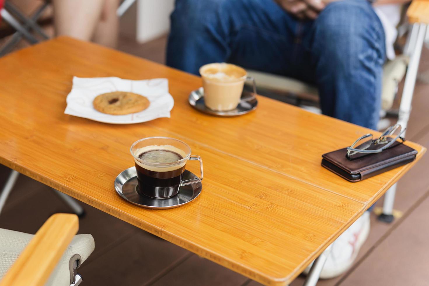 varm americano kaffe med cappuccino kaffe på trä- tabell. foto