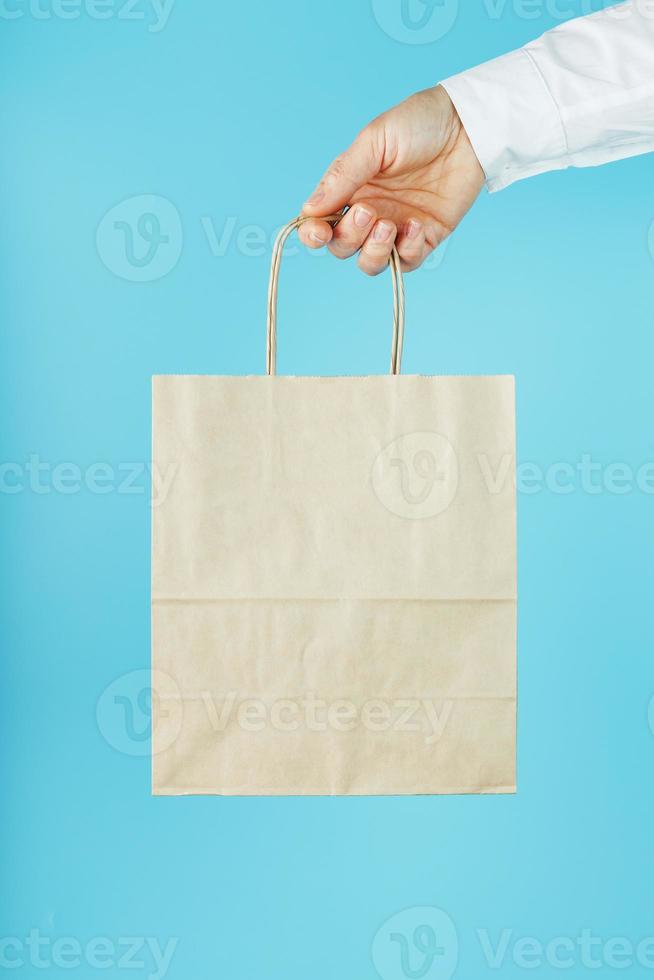 papper väska på vapen längd, brun hantverk väska för hämtmat isolerat på  blå bakgrund. förpackning mall layout med Plats för kopiering, reklam.  13224008 Arkivfoto på Vecteezy