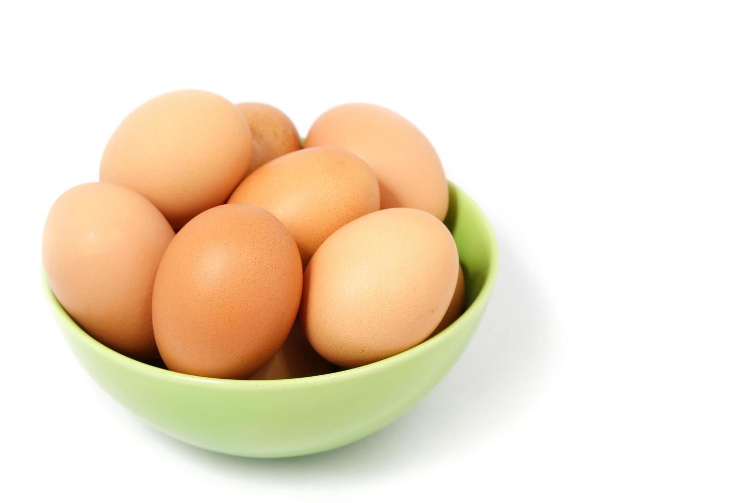 ägg i kopp med vit bakgrund foto