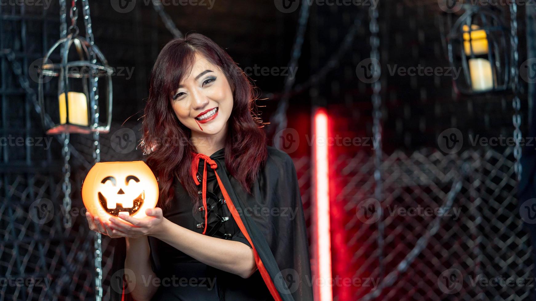 porträtt skön kvinna bär häxa kostym innehav pumkin i halloween tema. foto