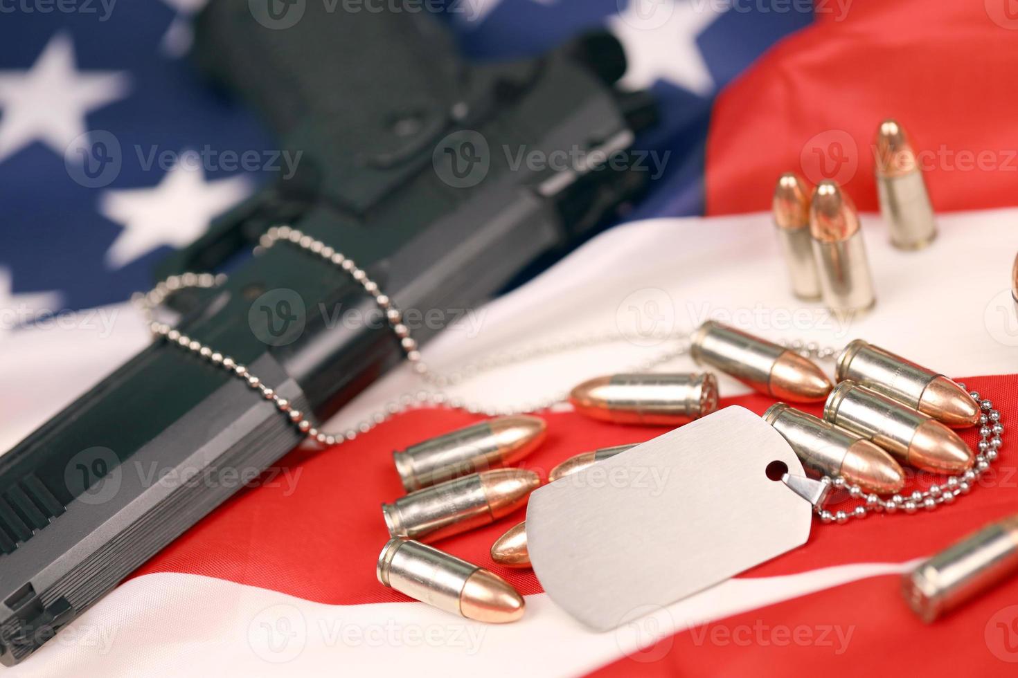 många gul 9mm kulor och pistol med dogtags på förenad stater flagga. begrepp av plikt och service i oss armén krafter foto