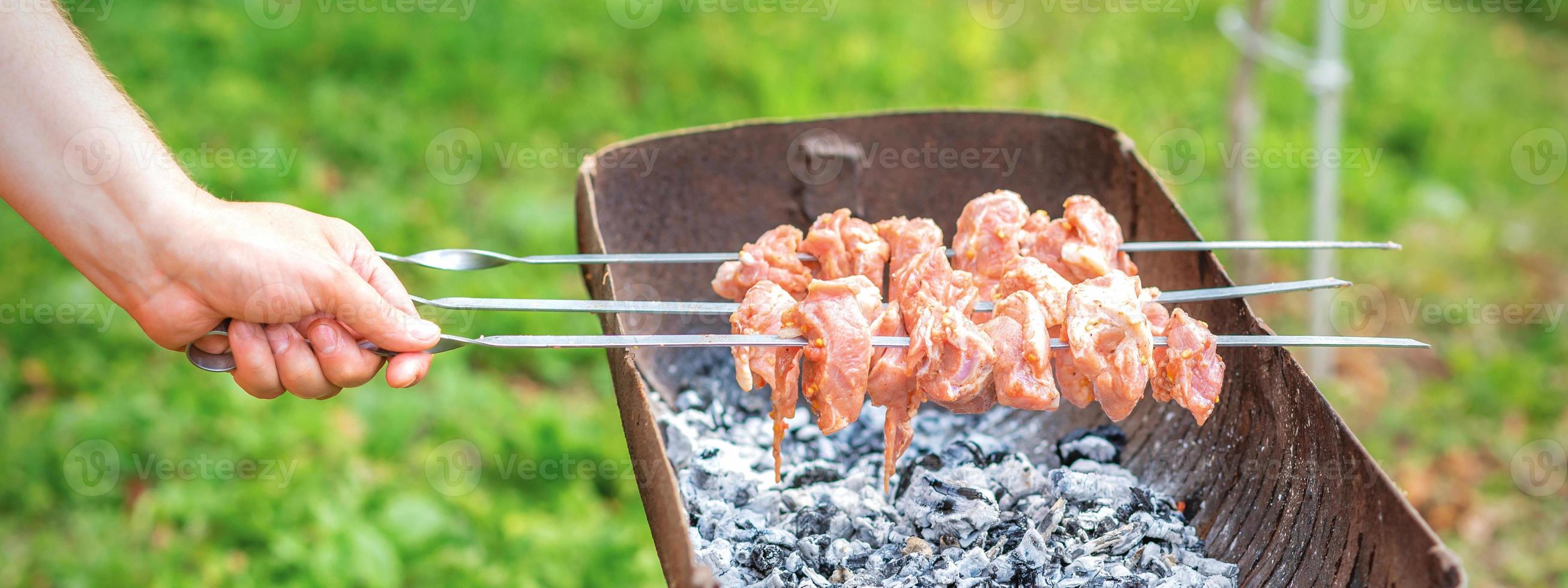 händer av man förbereder utegrill kött foto