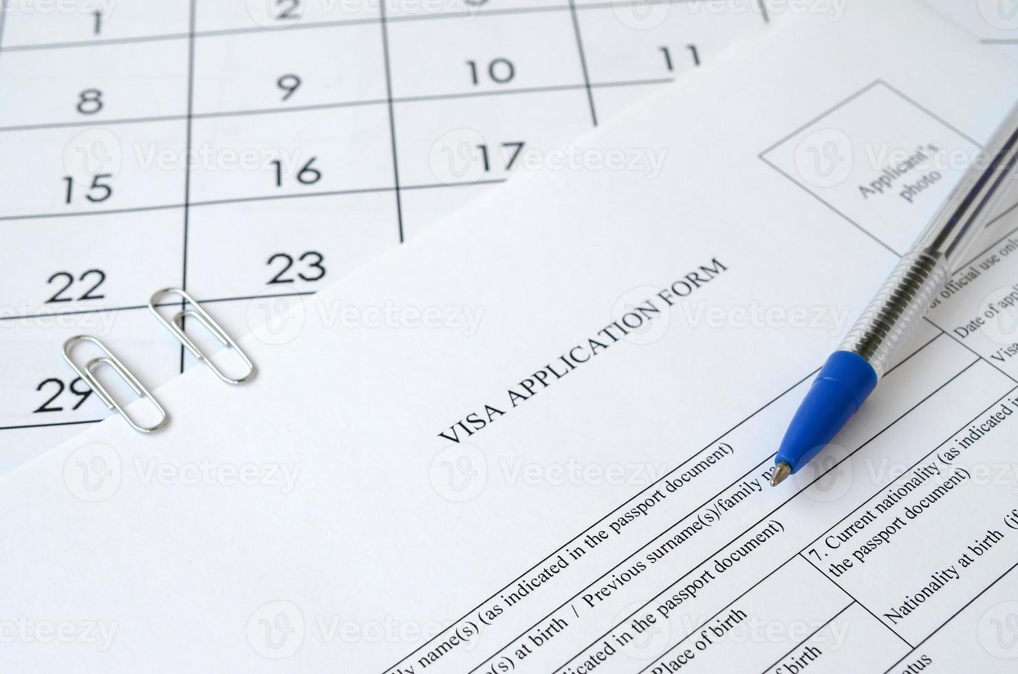 typisk visum Ansökan form och blå penna på papper kalender sida foto