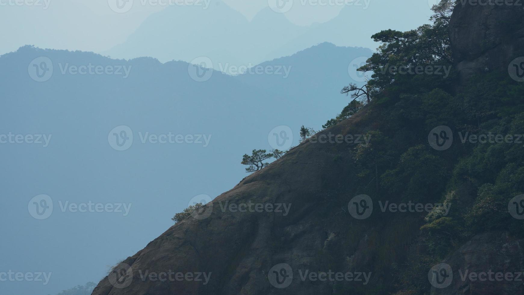 de skön bergen landskap med de grön skog och de bröt ut sten klippa som bakgrund i de landsbygden av de Kina foto