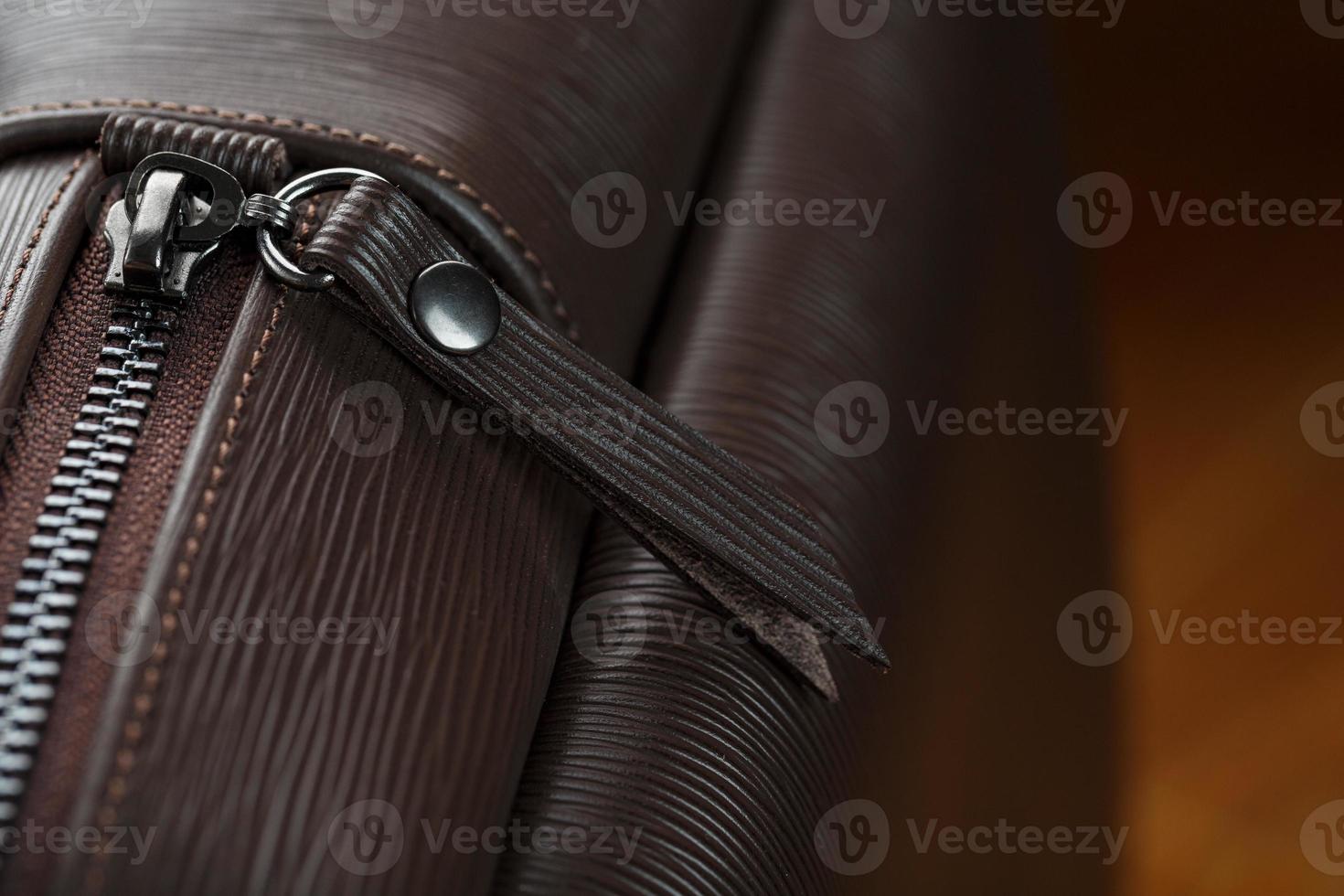 närbild element och detaljer av de ryggsäck tillverkad av brun äkta läder på en trä- bakgrund. foto