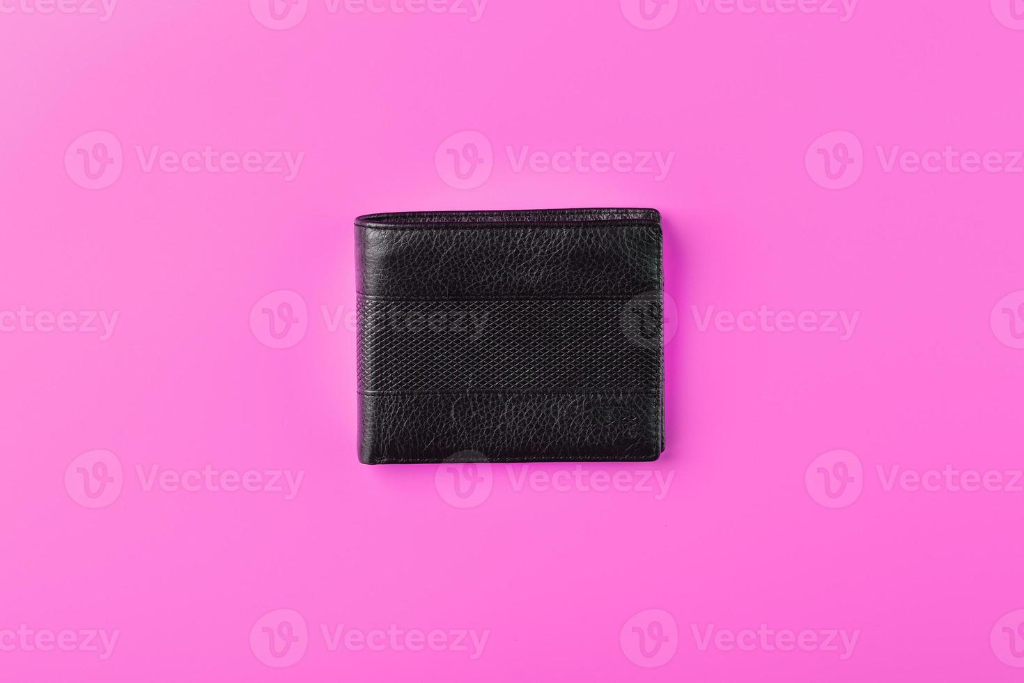 svart plånbok på rosa bakgrund. symbol av välstånd och välstånd. foto