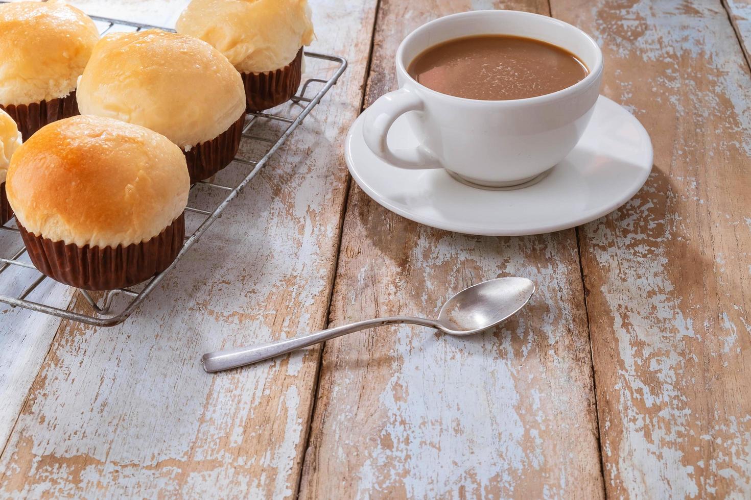 färska muffins och kaffe på träbord foto