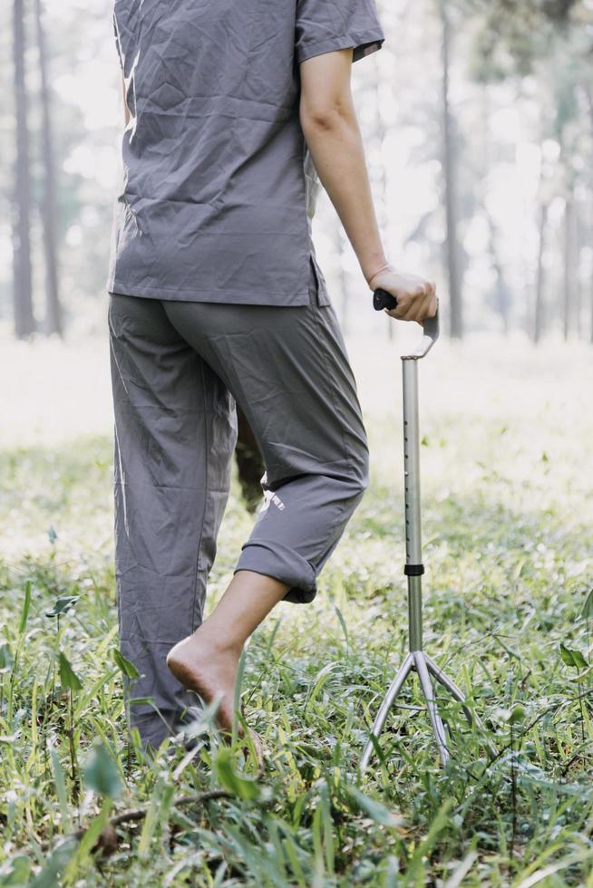 ung asiatisk fysisk terapeut arbetssätt med senior kvinna på gående med en rollator foto