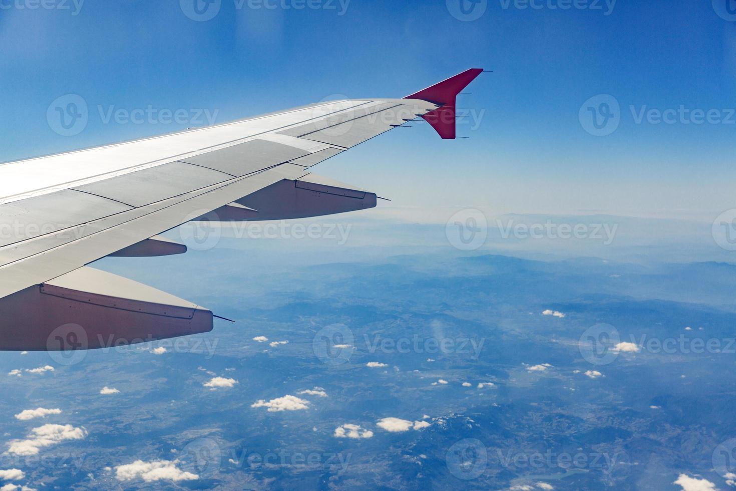 flygplan vinge på de moln, flugor på de stad bakgrund foto