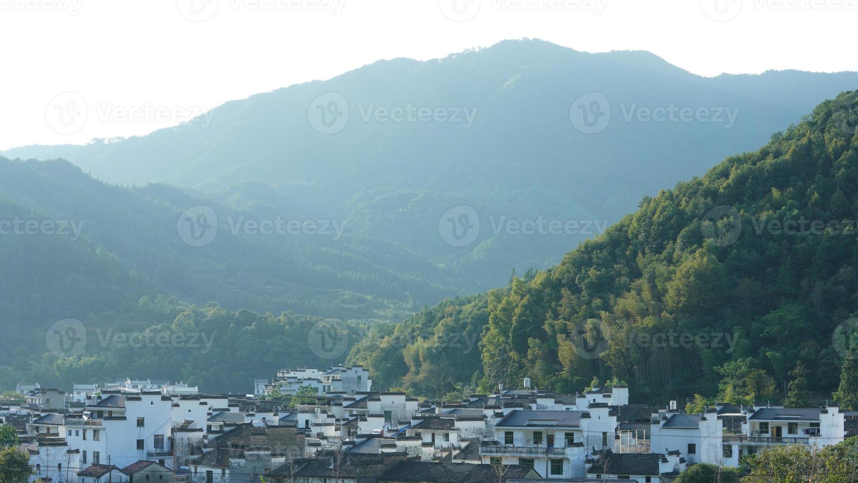 de skön traditionell kinesisk by se med de klassisk arkitektur och färsk grön träd som bakgrund foto