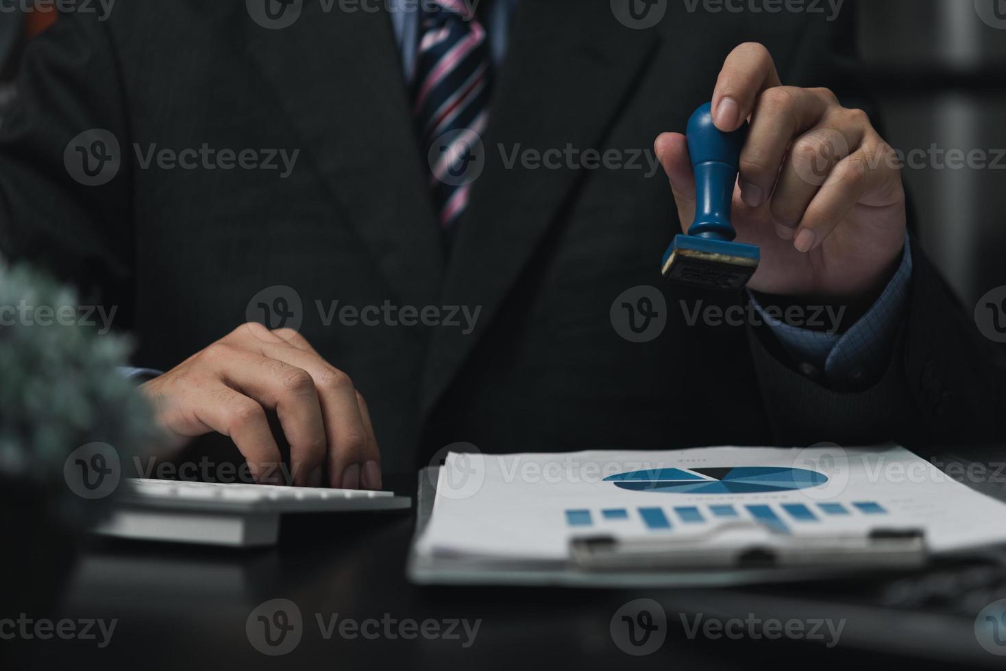 man stämpling godkännande av arbete finansiera bank eller investering marknadsföring dokument på skrivbord. foto